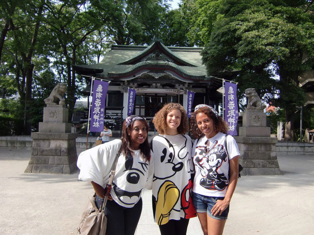KCP students Mickey fans pose in front of a shrine at Kameari.